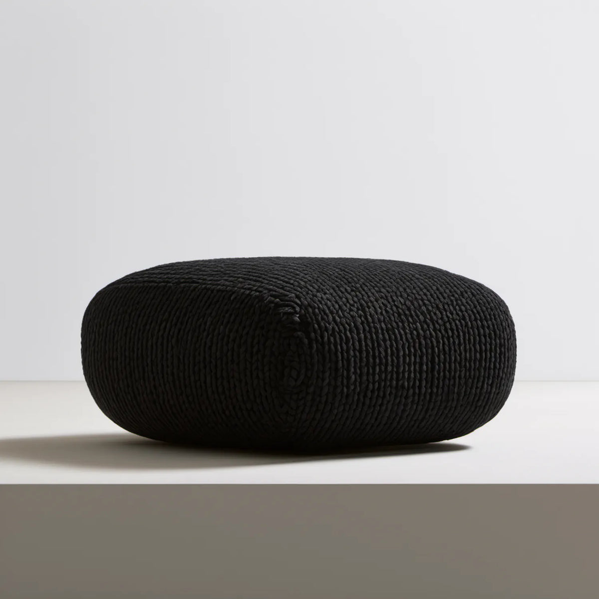Czarny tapicerowany puf zaokrąglony 70 x 70 x 35 cm z dzianiny poliestrowej